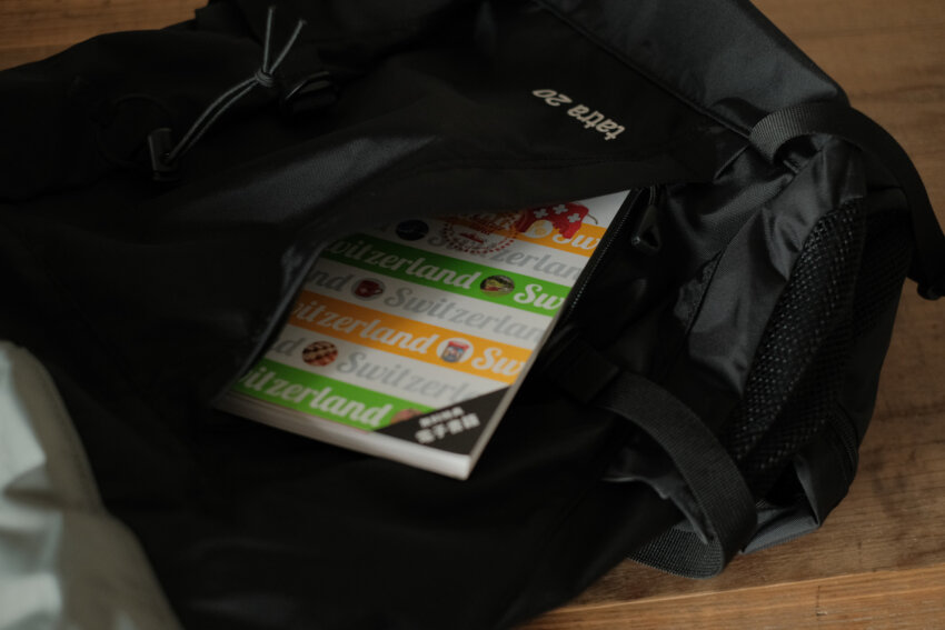 カリマータトラ20のフロントポケットにガイドブックを入れている様子