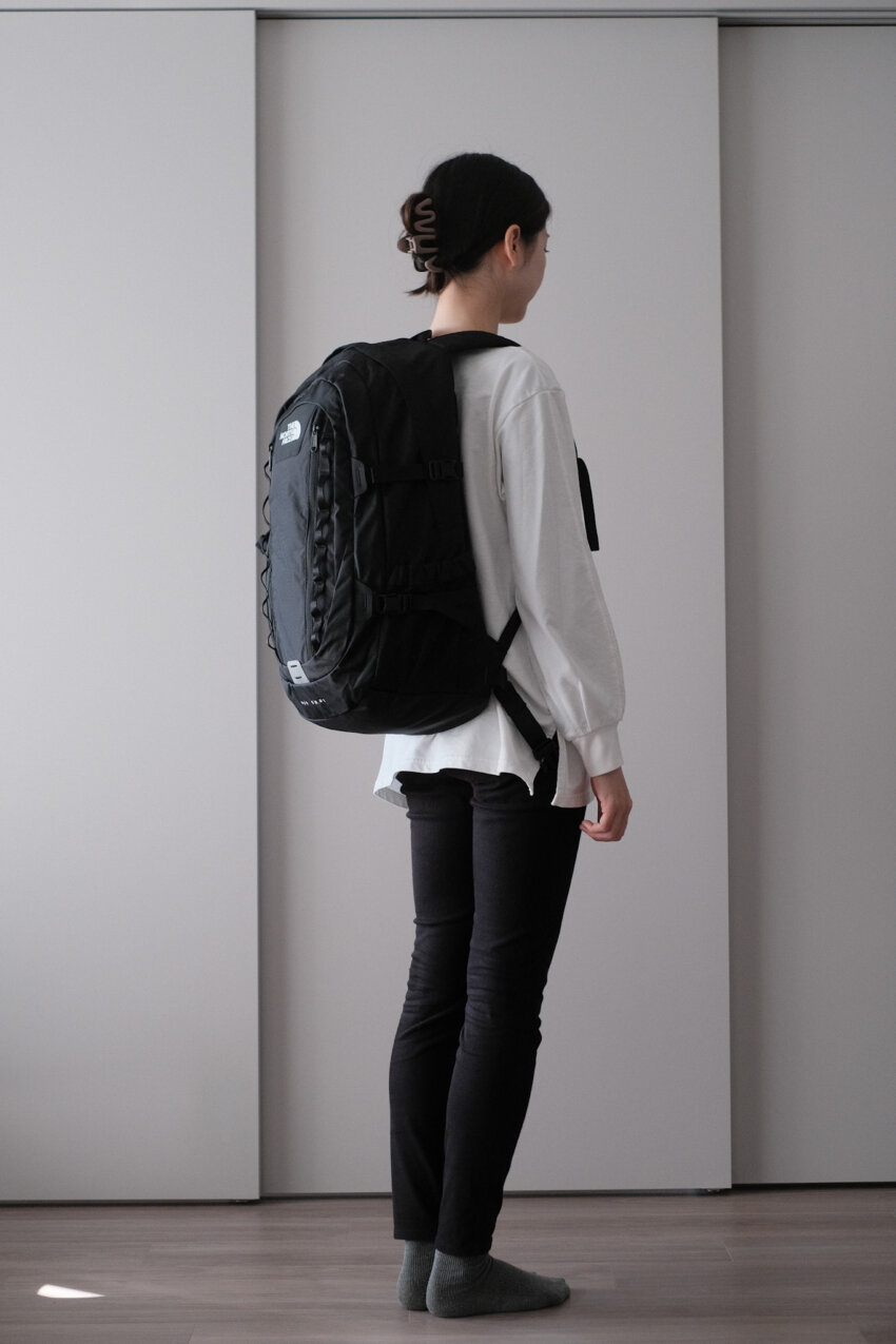 ノースフェイスビッグショットを背負った女性の後ろ姿