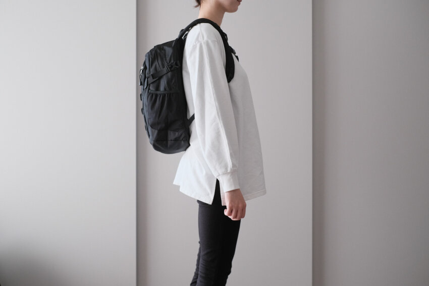 ノースフェイスミニショットを背負った女性の側面