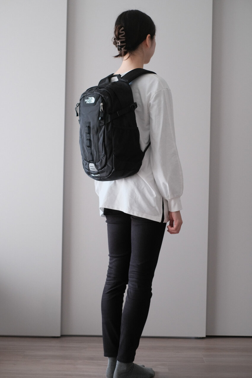 ノースフェイスミニショットを背負った女性